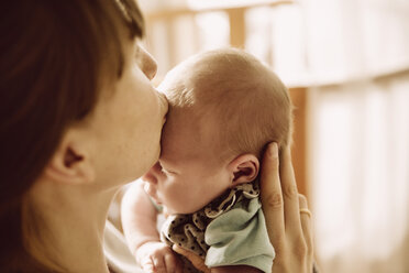 Mother kissing her newborn baby on forehead - MFF03420