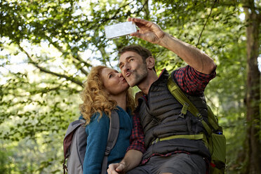 Wanderndes Paar macht Selfies mit Smartphone im Wald - FMKF03345