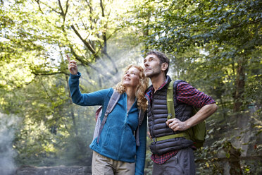 Couple hiking in forest, pointing at something - FMKF03347