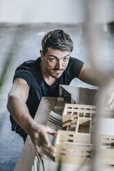 Portrait of confident architect working on architectural model - KNSF00863