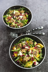 Two bowls of avocado salad with rocket, pomegranate seed, kaki, feta and walnuts - SARF03101