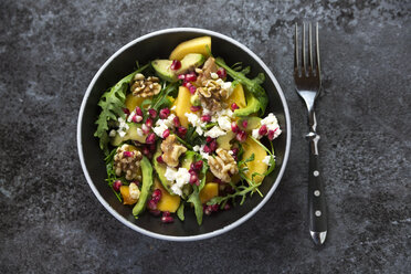 Bowl of avocado salad with rocket, pomegranate seed, kaki, feta and walnuts - SARF03102