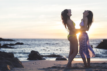 Zwei schöne junge Frauen im Bikini am Strand bei Sonnenuntergang - ZEF12010