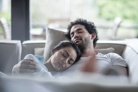 Young couple sleeping on a couch stock photo