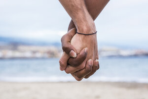 Nahaufnahme von zwei verbundenen Händen am Strand - SIPF01207