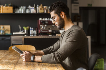 Junger Mann benutzt digitales Tablet in einem modernen Büro - TCF05281