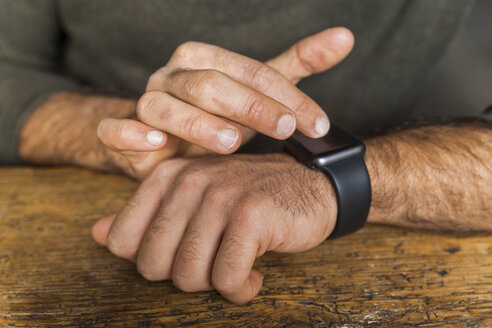 Nahaufnahme eines Mannes, der eine Smartwatch benutzt - TCF05282