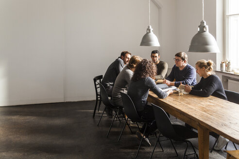 Coworkers having a meeting in modern office - TCF05286