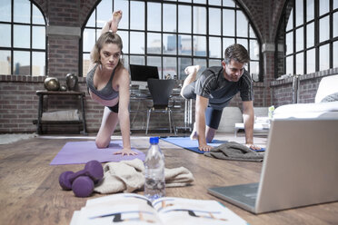 Junger Mann und Frau mit Laptop machen Yoga-Übungen - ZEF12044
