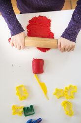 Kleines Mädchen rollt rote Knetmasse aus, Ansicht von oben - LVF05768