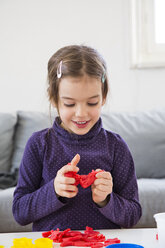 Kleines Mädchen knetet rote Modelliermasse - LVF05771