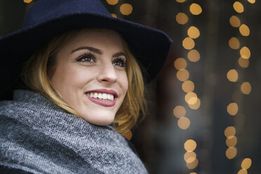 Portrait of smiling young woman wearing hat and scarf - KKAF00239