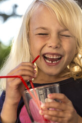 Laughing little girl drinking water with drinking straw - JFEF00825