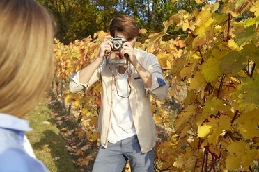 Mann fotografiert eine Frau in einem Weinberg - FMKF03372