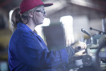 Woman using Vernier caliper in workshop - ZEF12117