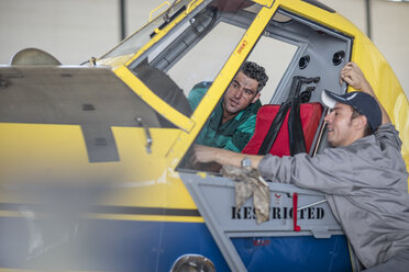 Mechanics in hangar repairing light aircraft - ZEF12142