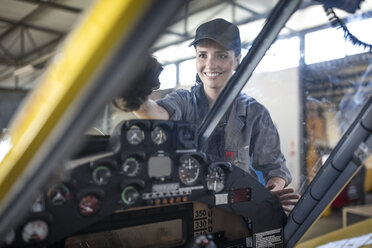 Mechaniker im Hangar beim Reinigen der Windschutzscheibe eines Leichtflugzeugs - ZEF12143