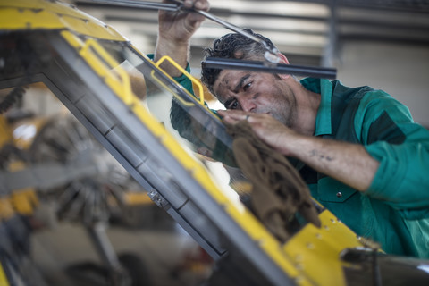 Mechanic in hangar repairing light aircraft stock photo