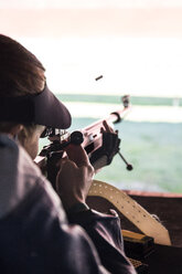 Kugel in der Luft, nachdem eine Frau mit ihrem Sportgewehr auf einem Schießstand geschossen hat - ABZF01703