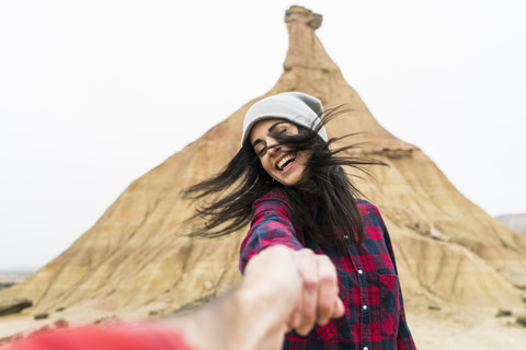 Spain, Navarra, Bardenas Reales, moving young woman holding hand of her boyfriend stock photo