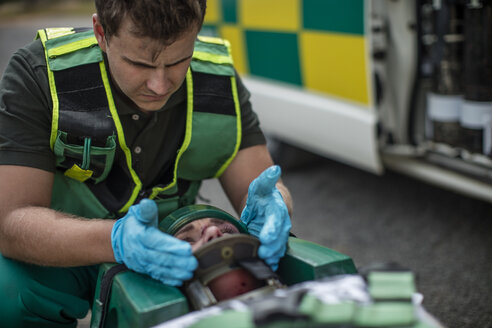 Paramedic fixing head of car crash victim on stretcher - ZEF12176