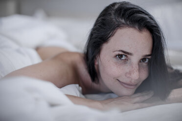 Porträt einer lächelnden jungen Frau im Bett liegend - ZEF12214