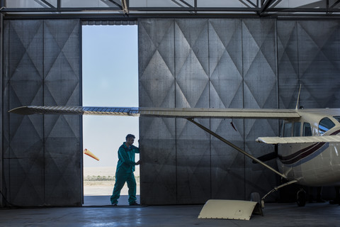 Mechaniker öffnet Hangartor, lizenzfreies Stockfoto