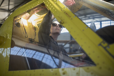 Female pilot inspecting light aircraft cockpit - ZEF12240