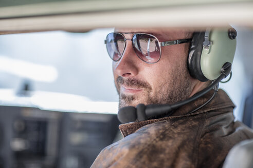 Junger Pilot im Cockpit sitzend, Porträt - ZEF12247