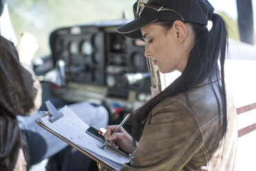 Pilotin inspiziert das Cockpit eines Leichtflugzeugs - ZEF12249