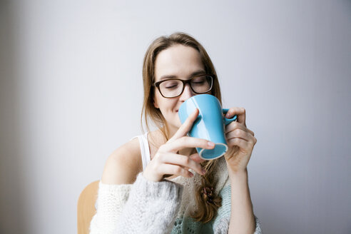Junge Frau trinkt zu Hause eine Tasse Kaffee - VABF00983