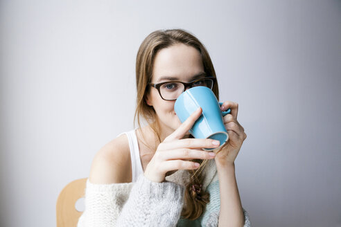 Junge Frau trinkt zu Hause eine Tasse Kaffee - VABF00984