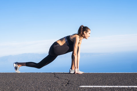 Junge Frau beim Training auf leerer Straße, lizenzfreies Stockfoto