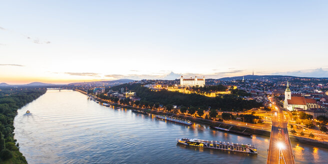 Slowakei, Bratislava, Stadtbild mit Flusskreuzfahrtschiffen auf der Donau in der Abenddämmerung - WDF03838