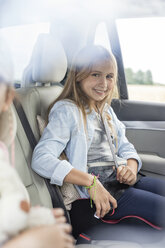 Girl sitting in car, fastening seat belt - WESTF22344