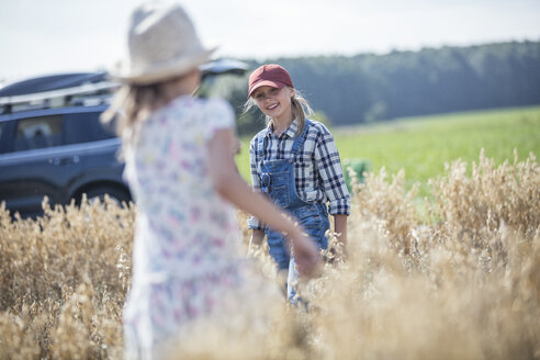 Zwei lachende Mädchen laufen im Feld - WESTF22351