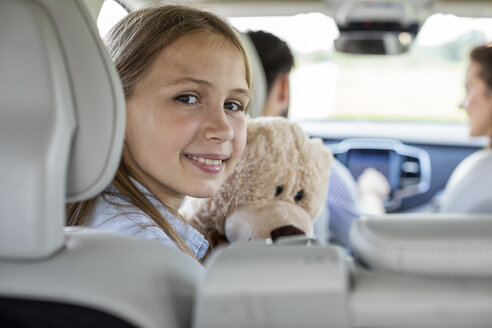 Glückliche Familie auf einer Autoreise, Tochter schaut in die Kamera - WESTF22355