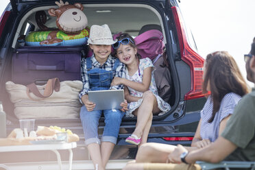 Glückliche Familie auf einer Autoreise, die eine Pause am Straßenrand einlegt - WESTF22384