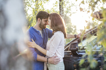 Couple embracing and kissing while on a road trip - WESTF22391