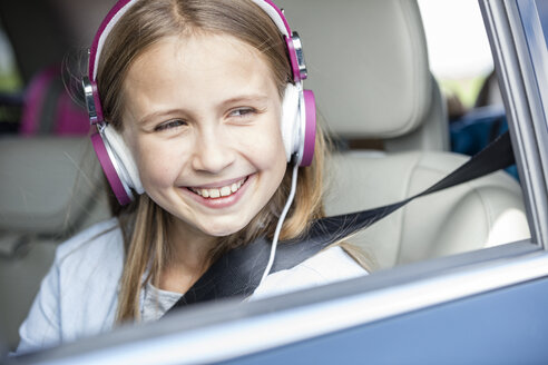 Mädchen sitzt im Auto, schaut aus dem Fenster, hört Musik - WESTF22407