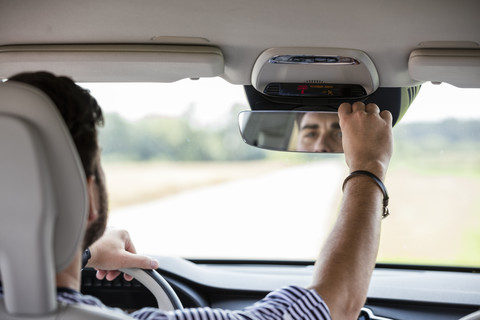 Mittlerer erwachsener Mann fährt im Auto, lizenzfreies Stockfoto