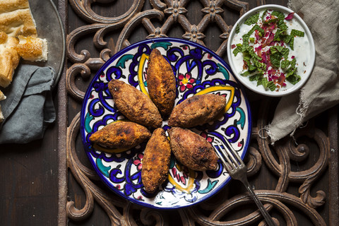 Kibbeh, oriental meat croquettes with yoghurt sauce on plate stock photo