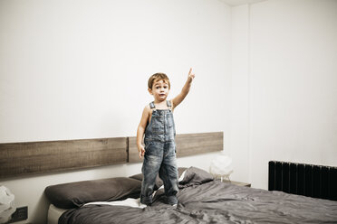 Kleiner Junge steht auf dem Bett seiner Eltern und zeigt auf etwas - JRFF01113
