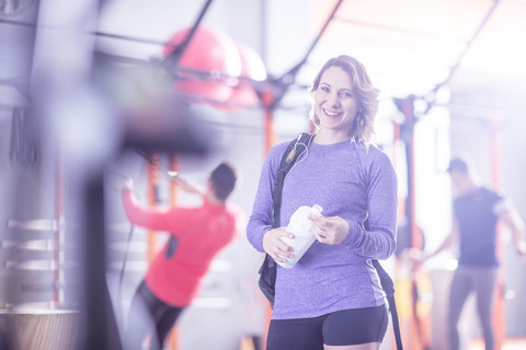 Porträt einer lächelnden jungen Frau im Fitnessstudio, lizenzfreies Stockfoto