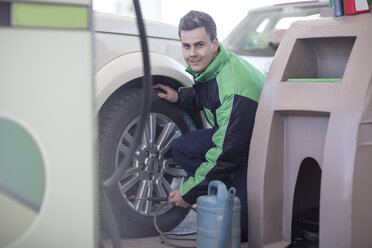 Mann füllt an einer Tankstelle Autoreifen mit Luft - ZEF12310