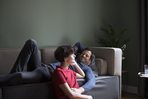 Couple relaxing together in the living room stock photo