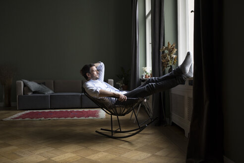 Man relaxing on rocking chair in his living room - RBF05480