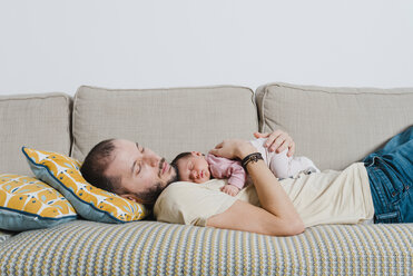 Father and his newborn daughter sleeping on the couch - GEMF01354