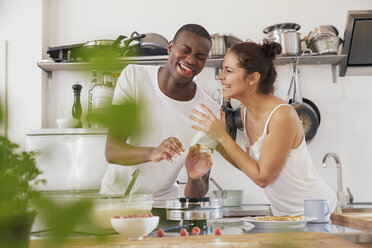 Junges Paar, das gemeinsam in der Küche Spaß hat - FMKF03407