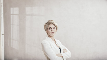 Porträt einer blonden Geschäftsfrau mit verschränkten Armen - FMKF03441